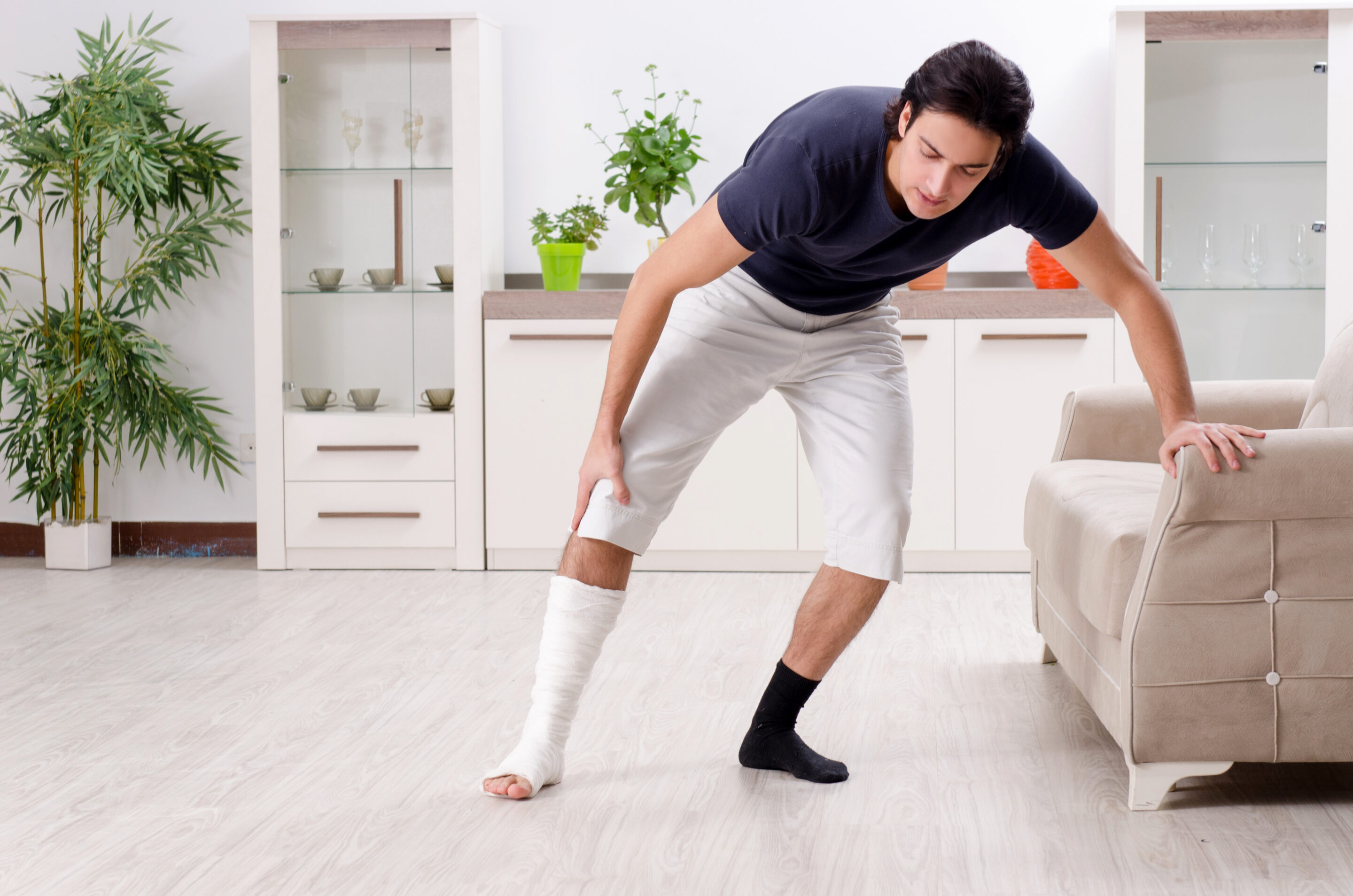 Leg injured young man suffering at home